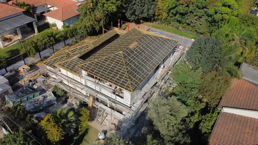 מבט אווירי על פרויקט בנייה בשלב מתקדם - גג עץ בהתקנה