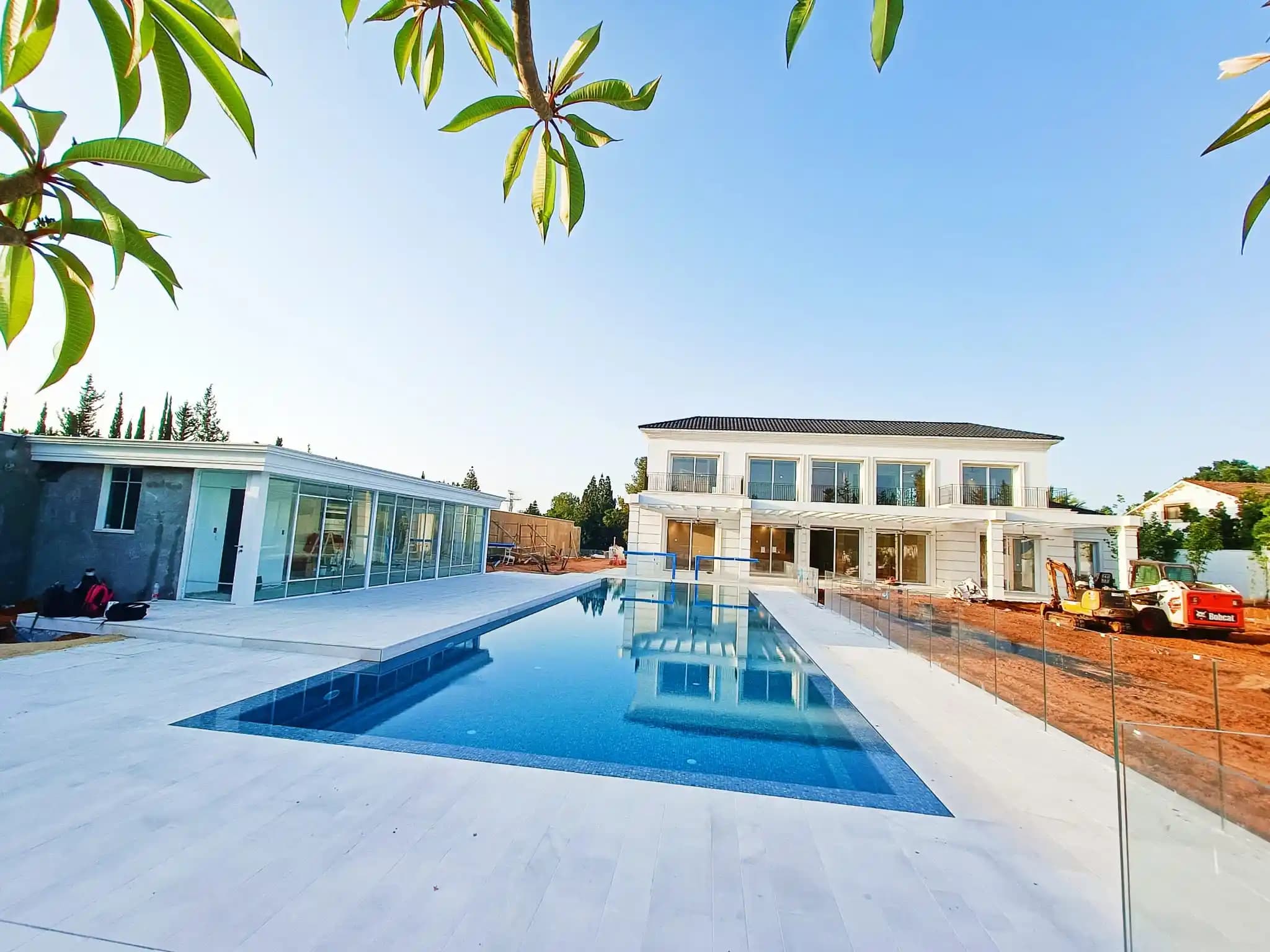 בית פרטי מודרני עם בריכת אינפיניטי ומבנה שירות עם חיפוי זכוכית