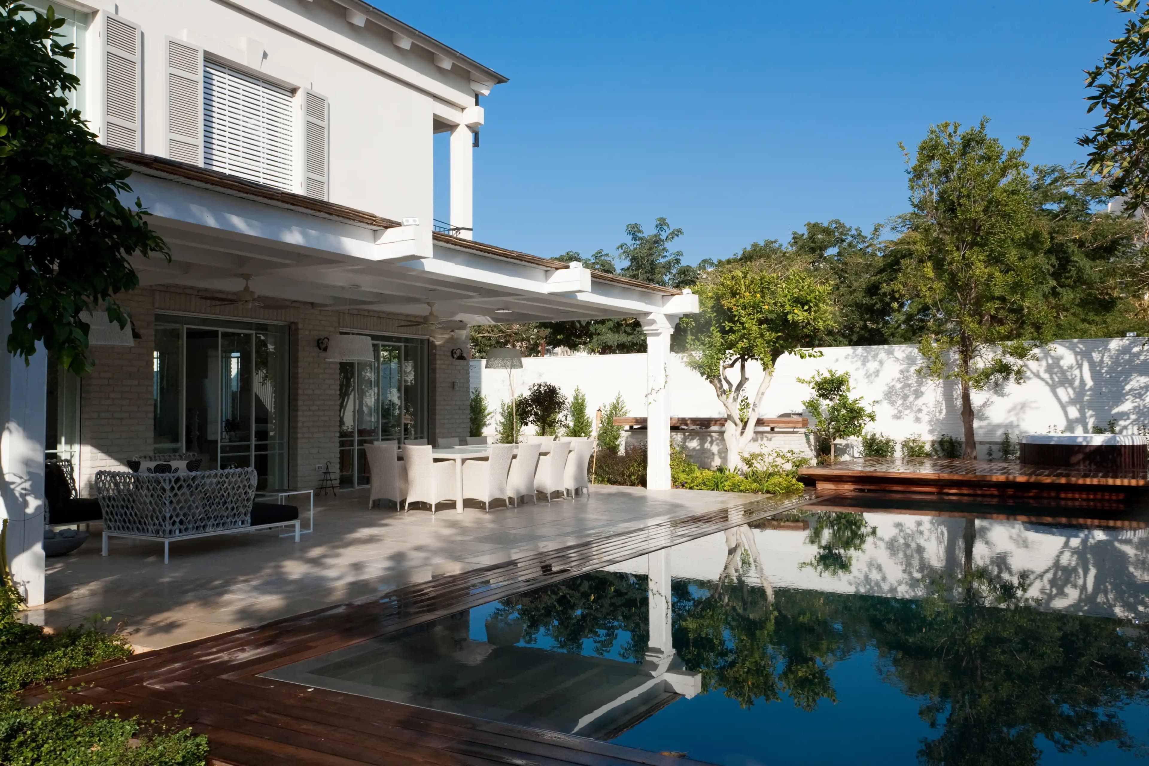 מרפסת אחורית יוקרתית עם בריכה פרטית ודק עץ איפאה