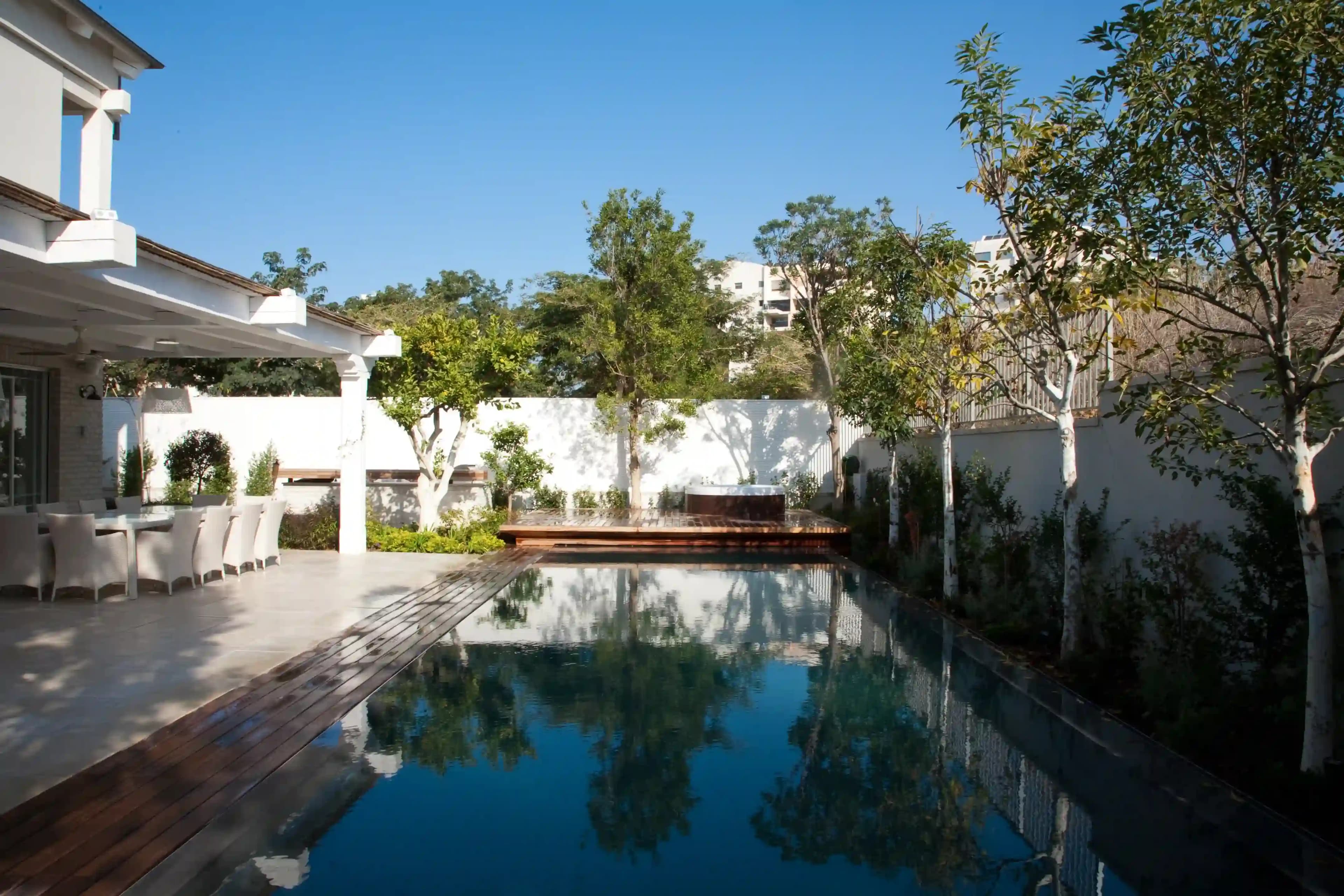 בריכת שחייה פרטית עם דק עץ ופינת ישיבה מעוצבת