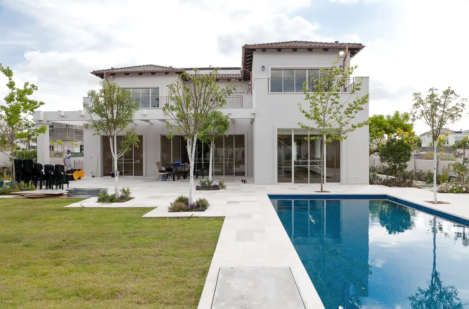 בית פרטי עם בריכת שחייה ארוכה וחצר מעוצבת עם דשא